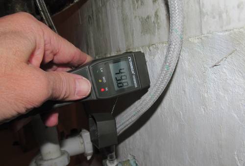 Figure 2: A moisture meter being used to detect hidden leaks in a kitchen. Access to moisture is crucial for German cockroach survival, making routine inspections essential for effective IPM programs in multi-unit housing. Photo credit: Herb Field